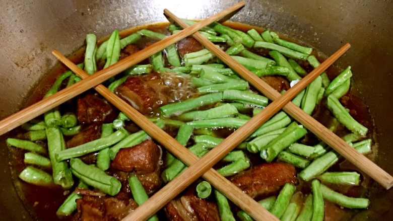 排骨豆角焖面,这时排骨炖烂,将豆角放入排骨中,然后往排骨豆角上横放几根筷子,利于架起面条。