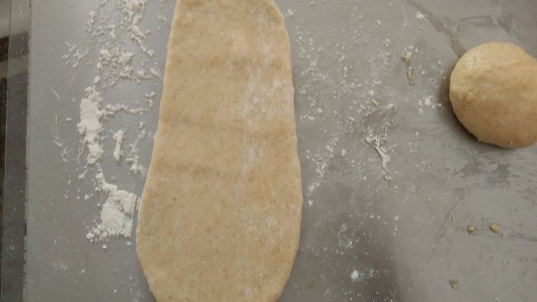 全蛋吐司,松驰好的面团分别擀成牛状,从上往下卷起。松驰15分钟后,再重复一次擀卷动作。
