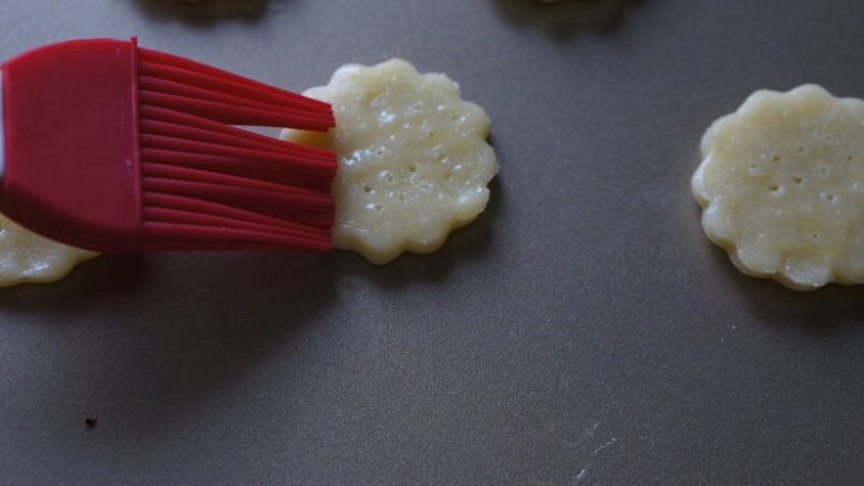 香脆的杏仁小酥饼,用叉子在饼干上扎上4排小孔,然后刷上鸡蛋液。
