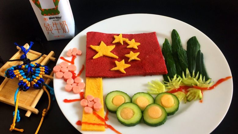 五星红旗迎风飘扬~中国必胜,将黄色的面饼切一个长条做旗杆,红色做五星红旗,黄色五角星放好,黄瓜皮羽毛远山,火腿片做梅花,黄瓜做五环,山脚下放好松枝,<a style='color:red;display:inline-block;' href='/shicai/ 699'>番茄酱</a>做树枝,五星红旗迎风飘扬,中国加油奥运勇夺金牌,为冠军喝彩!