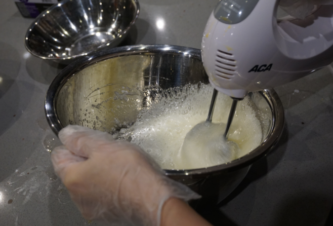 红丝绒蛋糕卷,把糖分次加入蛋清,用电动打蛋器先低速打发蛋白,出现粗泡时用高速进行打发