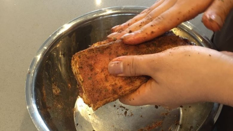 法式迷迭香烤小羔羊排,继续用手把调料和香料全部涂抹均匀在羊排上,然后放置腌制40分钟