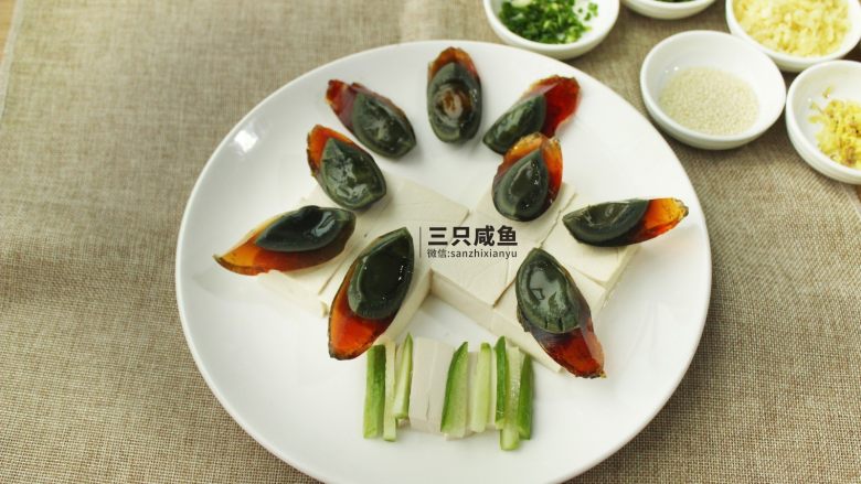 凉拌皮蛋豆腐,1个皮蛋切成4等份，依次摆入盘中，切<a style='color:red;display:inline-block;' href='/shicai/ 3488'>小黄瓜</a>摆盘，<a style='color:red;display:inline-block;' href='/shicai/ 2794'>大蒜</a>、葱花、青椒、<a style='color:red;display:inline-block;' href='/shicai/ 3446'>红尖椒</a>切成碎末备用