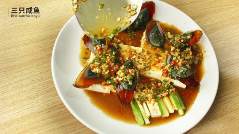 凉拌皮蛋豆腐,将配好的料汁均匀撒在盘子上
