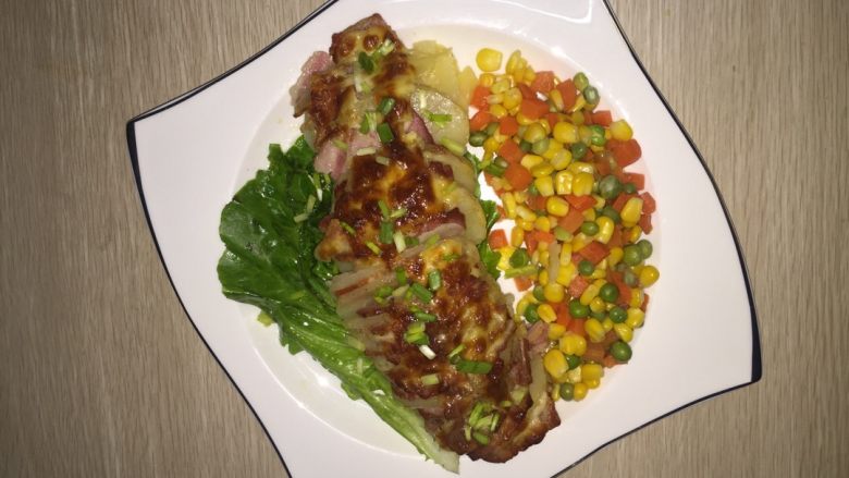 培根风琴土豆,最后把烤好的土豆放在生菜片上,撒点黑胡椒粉还有葱花,这样就大功告成咯!