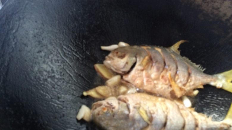 红烧䲝鱼,把姜片，大蒜，葱白放到锅底，爆一下