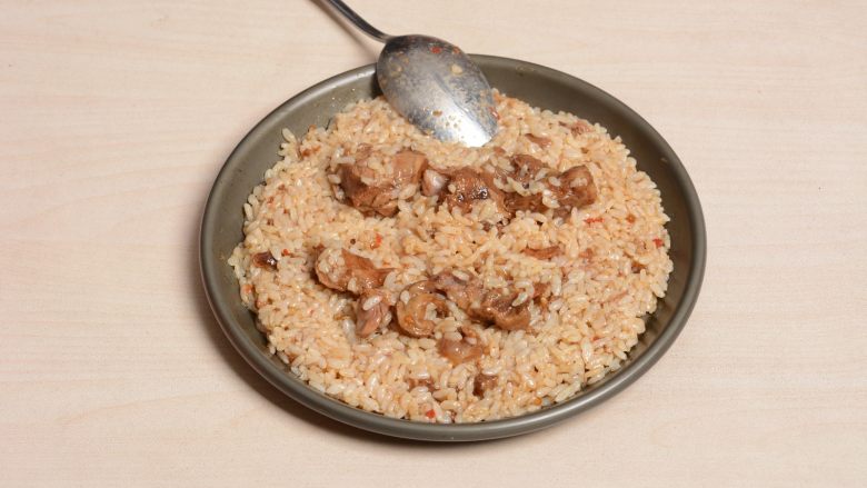 麻辣猪软骨铁盘焗饭,拌好的米饭在烤盘里铺均匀