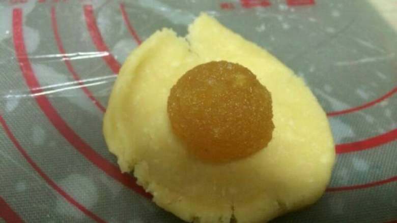 凤梨酥『简单版』,把馅分成每个都是15克的圆,酥皮也分成每个是15克的圆。『将酥皮按扁,包裹一个内馅。』