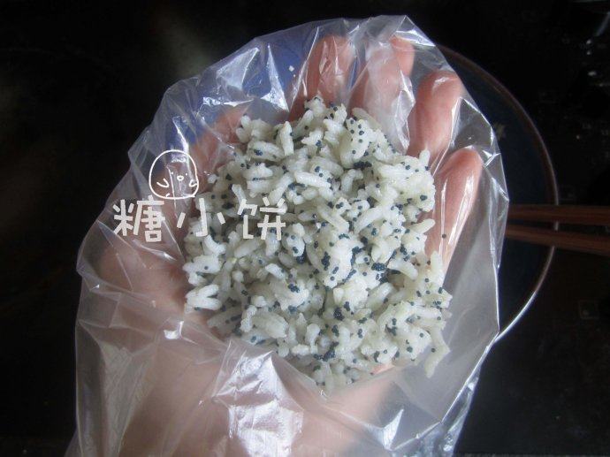 鱼籽三角饭团,手上套个小保鲜袋,把米饭放在手心。