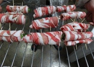 孜然羊肉菜卷,放在烤网上,入烤箱220度烤大概8分钟左右,中途撒烧烤料和盐调味,出炉后在撒一些烧烤料。