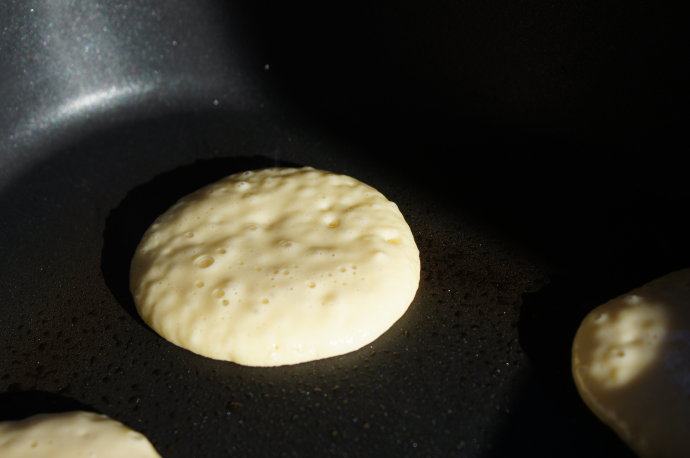 煎薄圆饼——Pikelets,平底锅加热,喷上少许油,将1汤匙面糊顺着勺子底部滴到平底锅里,我喜欢这样的电平底锅,每次可以煎好几个饼儿