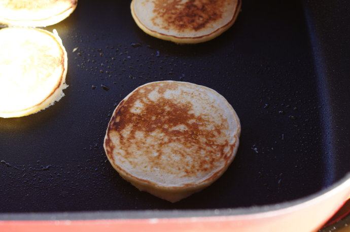 煎薄圆饼——Pikelets,大约2,3分钟后,看到面饼表面的泡泡开始被高温热爆后,将薄饼翻面,继续煎2-3分钟。