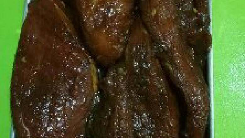 自制蜜汁叉烧(烤箱),从冰箱取出,去掉粘在肉上的蒜蓉,放在烤盘内。