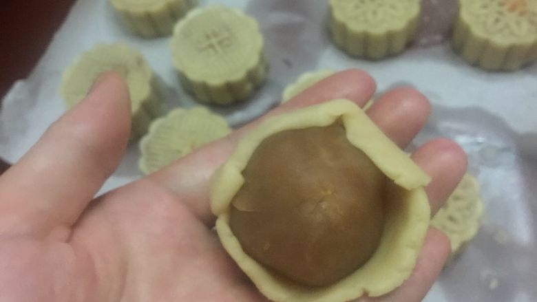 莲蓉蛋黄月饼,#把刚包好的莲蓉蛋黄馅,放入,慢慢把饼皮往上推#