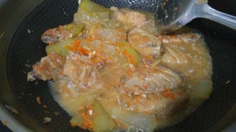 鸡翅冬瓜烧,撒入胡萝卜碎,加点盐,生抽翻炒均匀