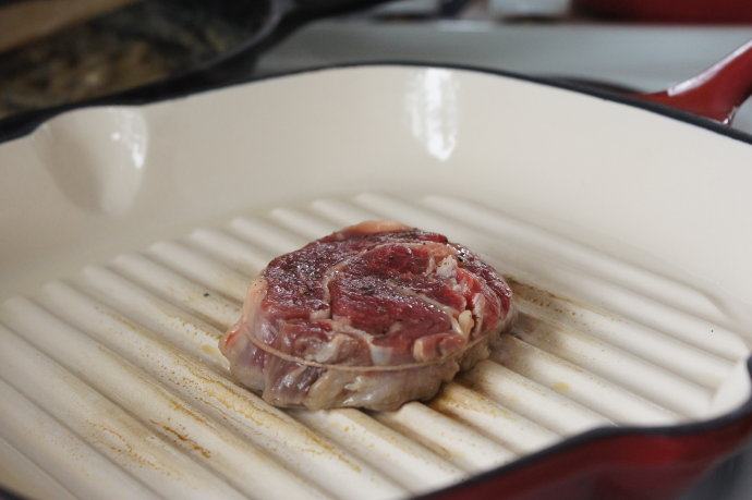 基础牛排——新西兰安格斯肉眼牛排,铸铁锅预热，放入牛排，每面煎3-5分钟，只翻面一次。