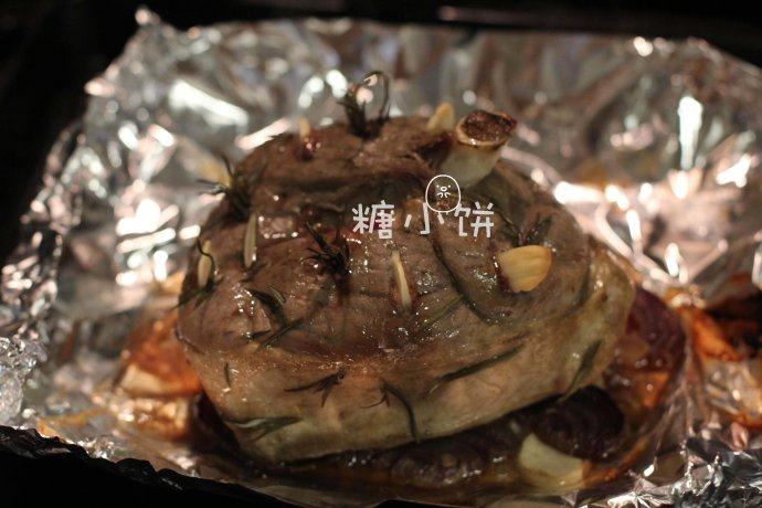 【迷迭香烤羊腿】中西混搭版,取出打开锡纸,去除表面烤干的迷迭香,撒一点干迷迭香,撒1汤匙白葡萄酒