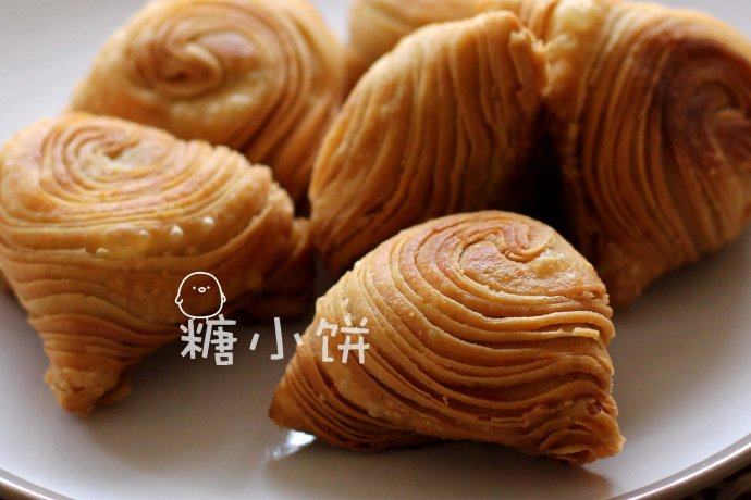 【咖喱酥角】,收口朝上下锅用热油炸,以下锅能迅速冒出密集的气泡为准,翻面再炸。因为馅料是熟的所以全程用中大火炸透,不需要转小火慢炸或者复炸。炸至表面金黄即可捞出控油,炸好的酥角表面层层起酥层次分明。