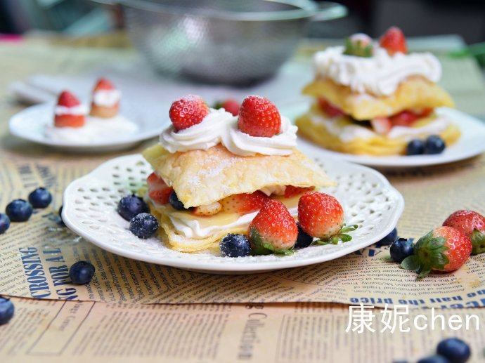 【水果拿破仑】,烤好的拿破仑酥要放凉后再挤上奶油馅,放奇异果块、蓝莓和草莓,再放拿破仑酥,挤上奶油馅或者撒上糖粉。