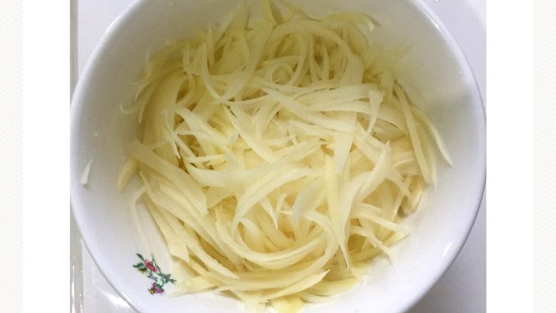 剁椒酸辣土豆丝#食材土豆#,用刨刀把土豆刨成细丝，小葱切葱花备用。