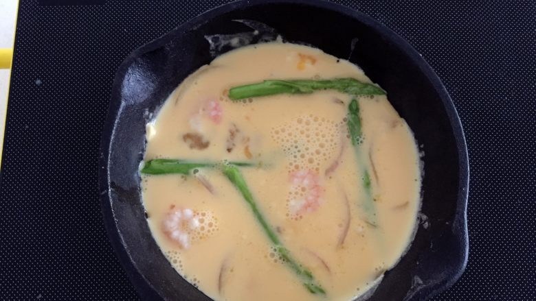 芦笋虾仁蛋饼—口感松软,补充丰富的蛋白质,稍稍晃动锅子,令蛋液均匀铺满,可以用筷子把芦笋和虾仁调整下位置,移到蛋液表面。