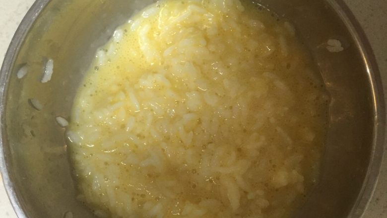 黄金蛋炒饭,将鸡蛋打散后倒入剩饭,翻裹均匀。这个就看个人喜好了,喜欢有大块鸡蛋感觉的可忽略这一步