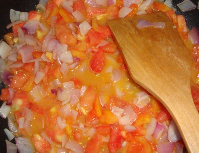 意大利美味——菠菜鸡肉排,黄油化开,放入另一半的洋葱丁炒至半透明,加入西红柿丁炒软,炖烂
