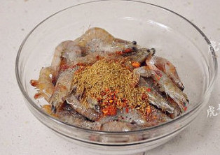 一烤即成的麻辣孜然脆皮虾,清理好的大虾放入碗中,加入所有调味料拌匀。