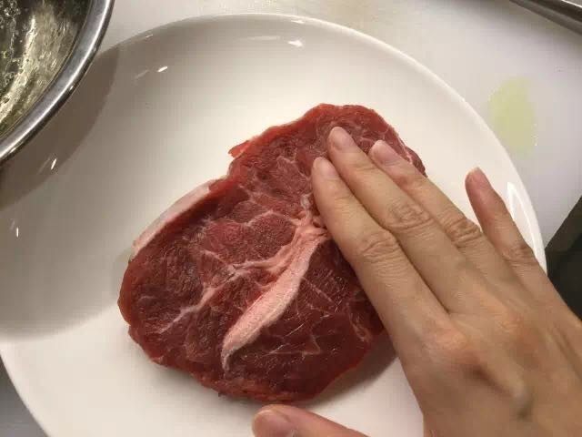 香煎牛扒配红酒汁,用手轻轻拍打牛肉，放松肉质