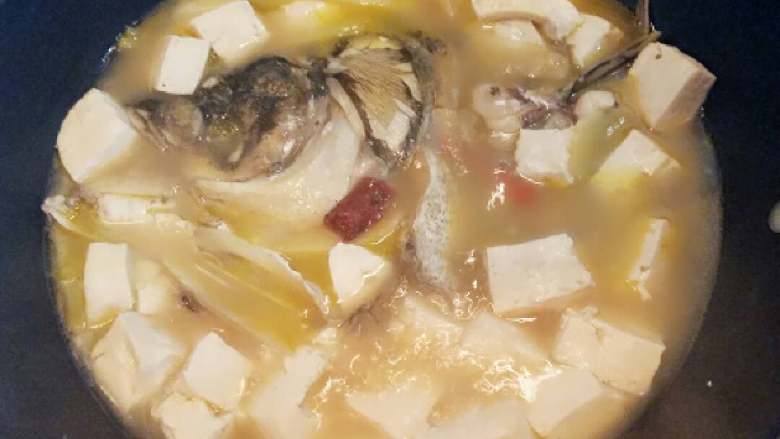 鱼头豆腐汤+#夏天的味道#,加入豆腐块，生姜片，葱段，适量的盐，白糖一点点，辣椒适量煮开后转小火慢慢炖。