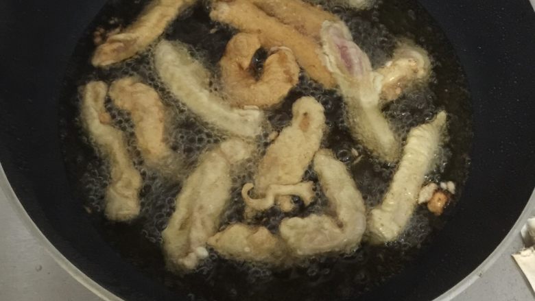 椒盐软炸里脊,油烧至五六成热,放入肉条炸至金黄色盛出。
油锅重新加热至六成热,把炸好的里脊肉再次放入锅中复炸一遍,盛出。