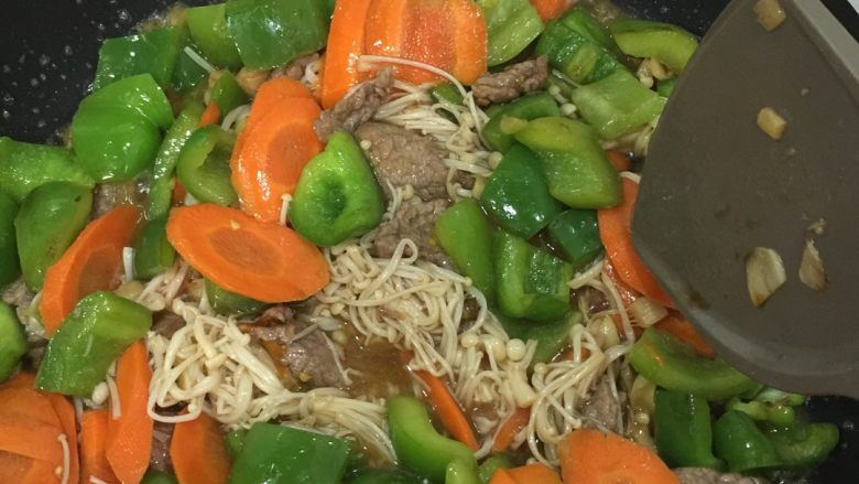 杂菜炒牛肉,放入之前炒过的菜椒胡萝卜，再加入金针菇，翻炒。
加入酱油，耗油调味，即可出锅。