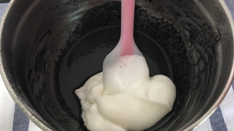 黑白蛋糕卷(竹炭卷),先取三分之一蛋白液放入蛋黄竹炭液,以切拌的方式融合拌匀