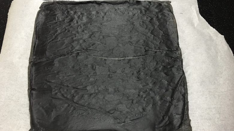 黑白蛋糕卷(竹炭卷),烤好的蛋糕取出后,撕掉四周烘焙纸散热.冷却后撕掉烘焙纸,将蛋糕片铺在一张新烘焙纸上.