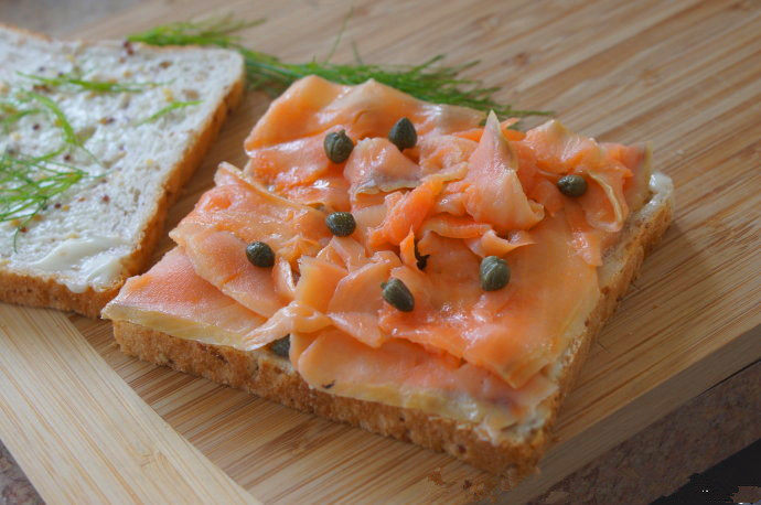 #夏天的味道#烟熏三文鱼三文治,铺上烟熏三文鱼片，再放上一些刺山柑，盖上另一片面包做成三文治。