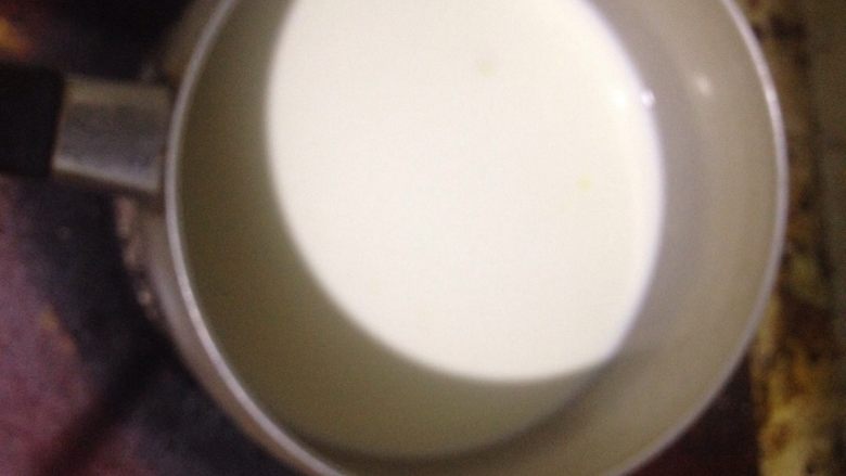 牛奶布丁,牛奶倒进奶锅。放在炉子上小火加热