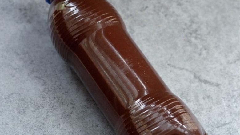 爆红可乐冰激淋蛋糕,盖上盖子，迅速摇匀，让巧克力粘在瓶壁上，尽量厚一点，冷藏1个小时