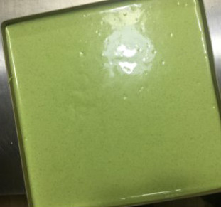 特浓抹茶蛋糕卷 ,将面糊从高处倒入铺过油布的烤盘中,双手端起烤盘向四角倾斜使面糊平整,厚薄均匀,震模一次入炉