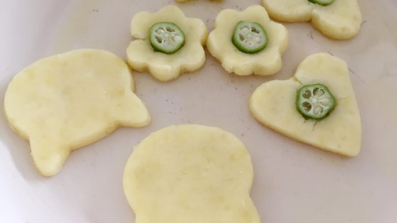 秋葵土豆饼,在土豆饼中间用手轻轻搓个痕迹,然后放入一小段秋葵即可。