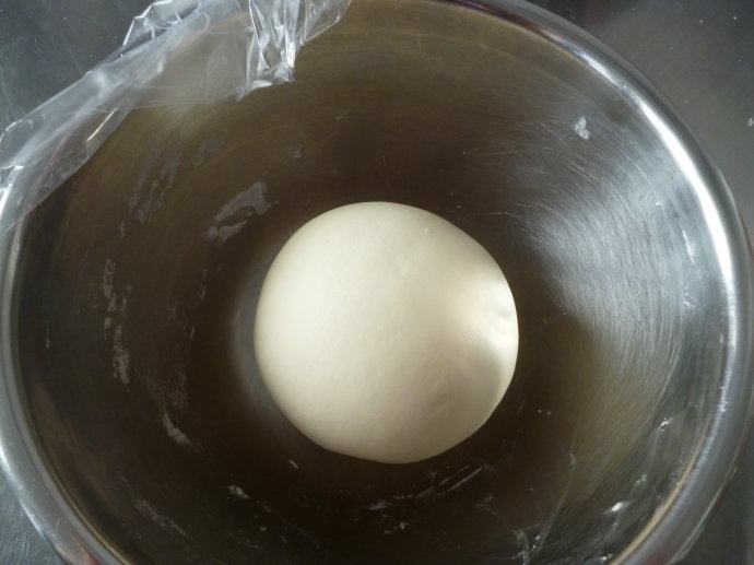 鲜美多汁~~虾肉生煎包,制作面团,酵母和糖加入温水中化开加入面粉混合成团并揉至表面光滑,表面覆盖保鲜膜(表面需涂抹些食用油)开始基础发酵。