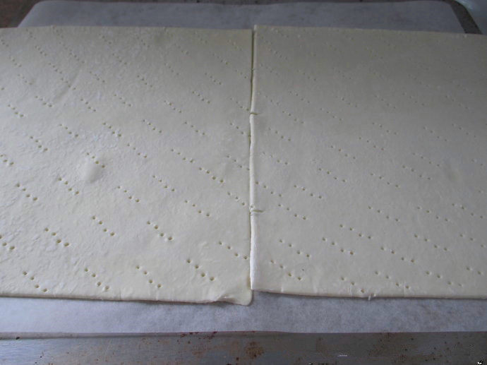 香草卡仕达方块——Vanilla Custard Squares ,解冻酥皮,把酥皮放在烤盘上,用叉子插许多洞洞