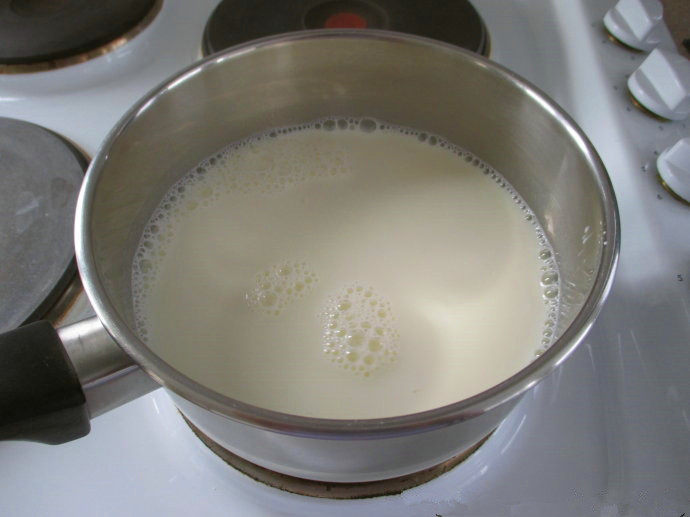 香草卡仕达方块——Vanilla Custard Squares ,准备卡仕达酱。中火加热2杯牛奶,加入糖
