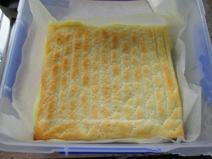 香草卡仕达方块——Vanilla Custard Squares ,铺上另一张酥皮,用手轻压。