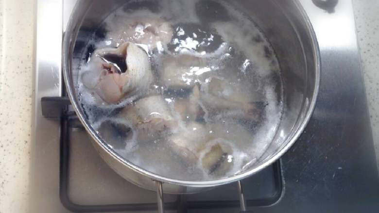 辣雪鱼汤,在汤锅里放入800ml水,等水开之后放入腌制好的雪鱼段,除去漂浮起来的浮末。