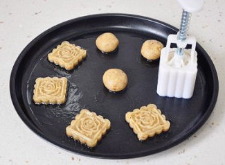 助兴小点心:核桃饼干,用月饼模具将小面球压出带着花纹的饼干坯。用力按压手柄直到按不动,这样提起模具饼干的花纹才清晰。