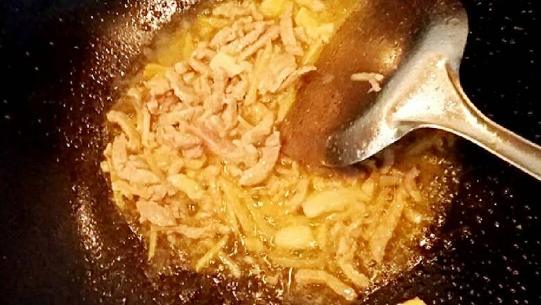 酸豆角炒肉丝(自制酸豆角),锅烧热加入适量的油,加入肉丝翻炒至白。