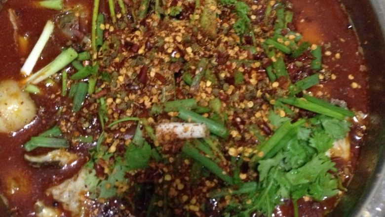 水煮鱼,然后倒入大碗里,依次铺上葱、香菜,调料辣椒粉包