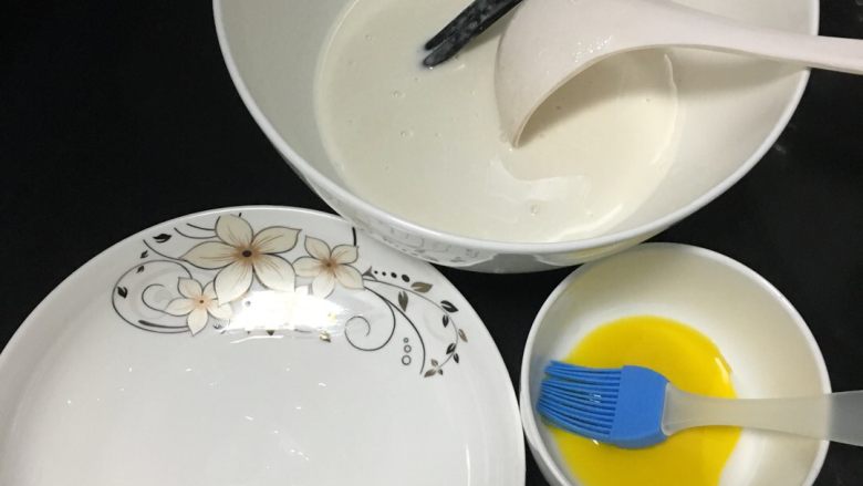 凉皮,把澄面浆的清水给倒出不用,再把面浆搅成面糊,准备一个空盘,适量的油和刷子