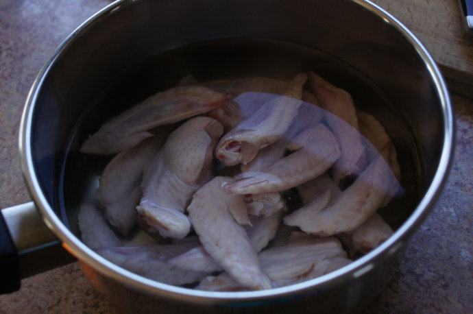 凤梨苦瓜鸡汤--清凉的苦尽甘来 ,把鸡翅洗净，切块，放入锅里加入水煮开，断生后起锅，用水冲干净。
（某天烤鸡翅，KK同学不吃鸡尖部分，连同两对翅膀，某把其他鸡尖一并用来做汤，喝口好汤比直接扔掉强吧？）