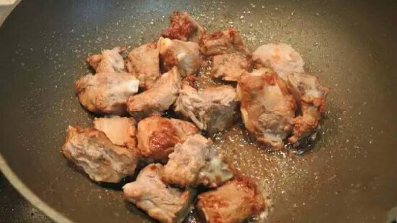 红烧排骨,在所有冰糖完全起泡时一瞬间将排骨下入锅中,翻炒均匀,可以更好的上色并锁住排骨的水分,吃起来口感细腻、鲜嫩可口,不像干柴一样。加入葱姜、辣椒、花椒继续翻炒。